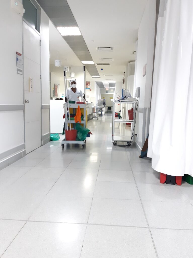 working woman pushing colorful cleaning cart