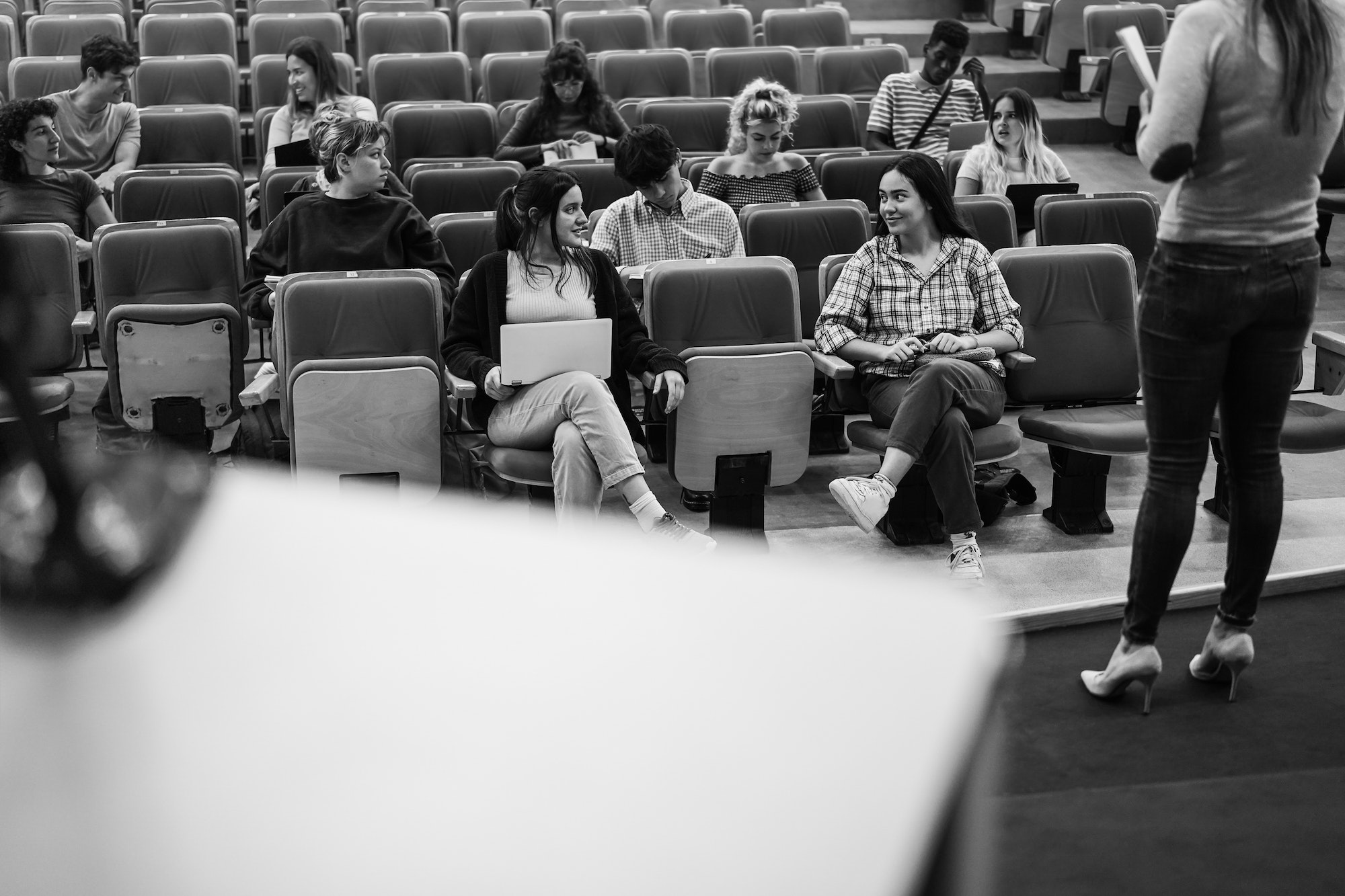 Young students listening to conference seminar inside auditorium university